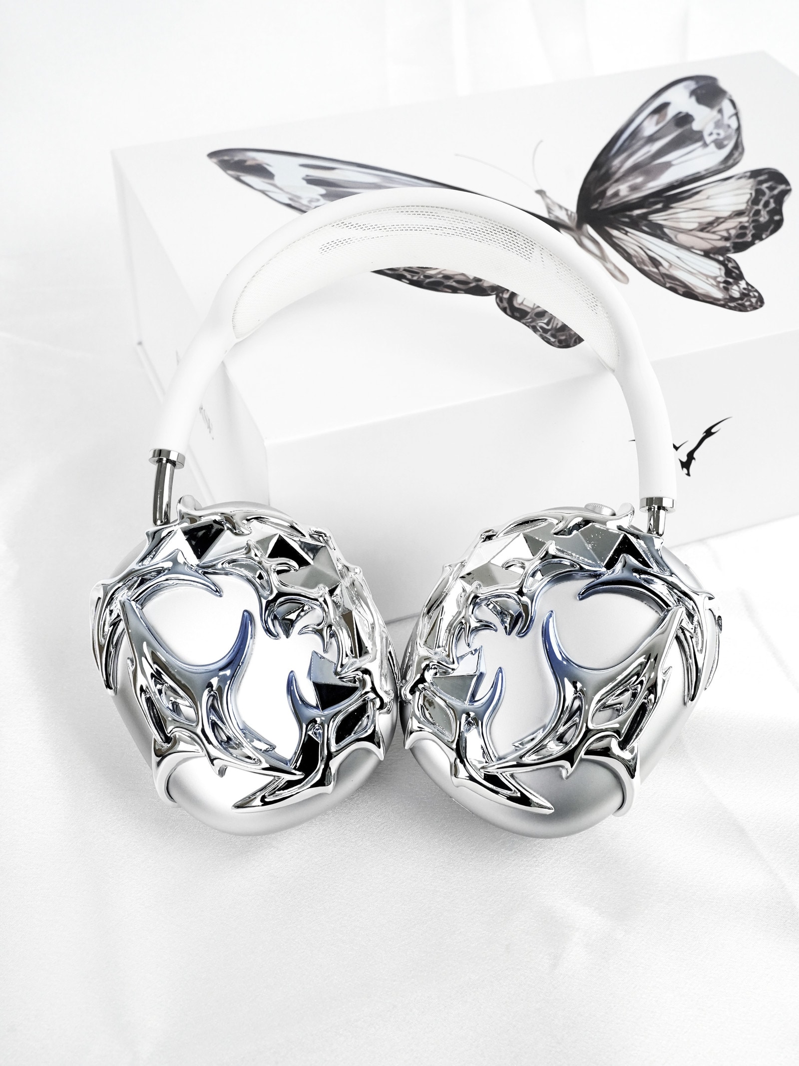 Chrome Eri Verse attachments on white headphones, resting on the butterfly box