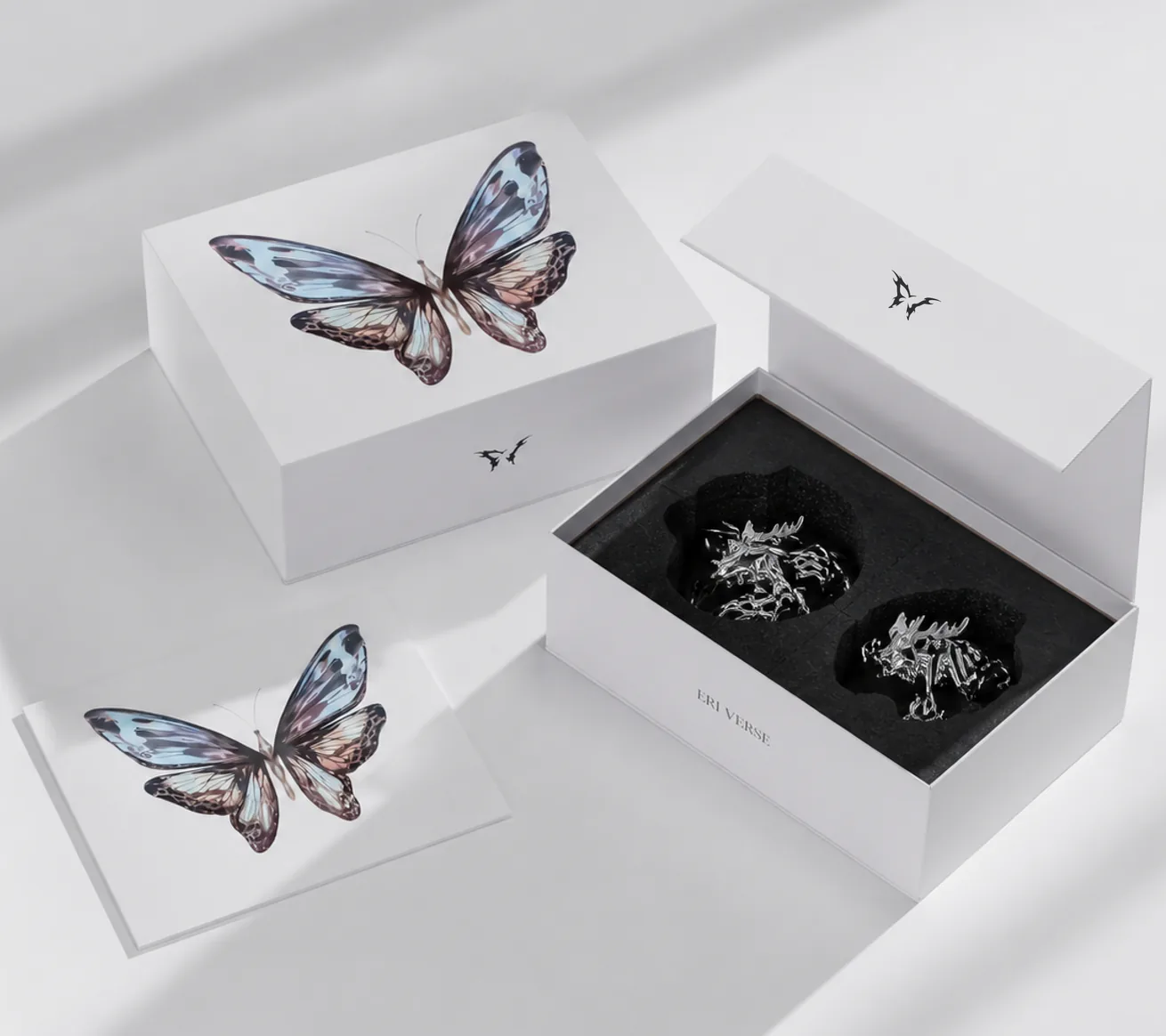 Eri Verse packaging: butterfly-printed boxes with a pair of pieces seated in black foam